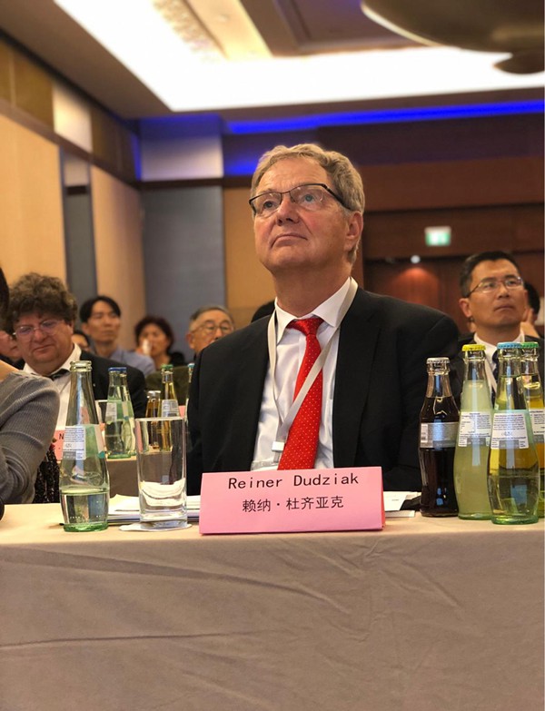 德國分賽區(qū)現(xiàn)場，賴納·杜齊亞克教授正在認(rèn)真的聆聽參賽選手路演。