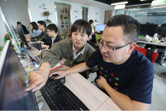 寧新鵬和同事討論技術(shù)上的問題。
